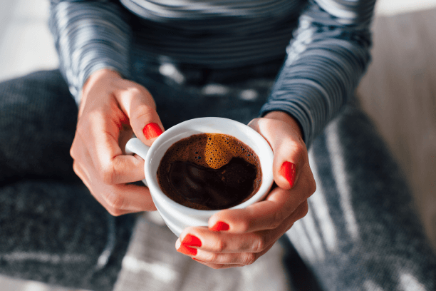 A person having black coffee happily A person having black coffee happily