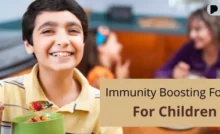 A smiling child holding a bowl of healthy food that helps build immunity in children